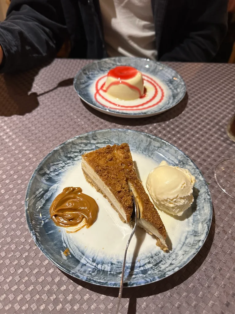 A slice of cheesecake served with ice cream and caramel