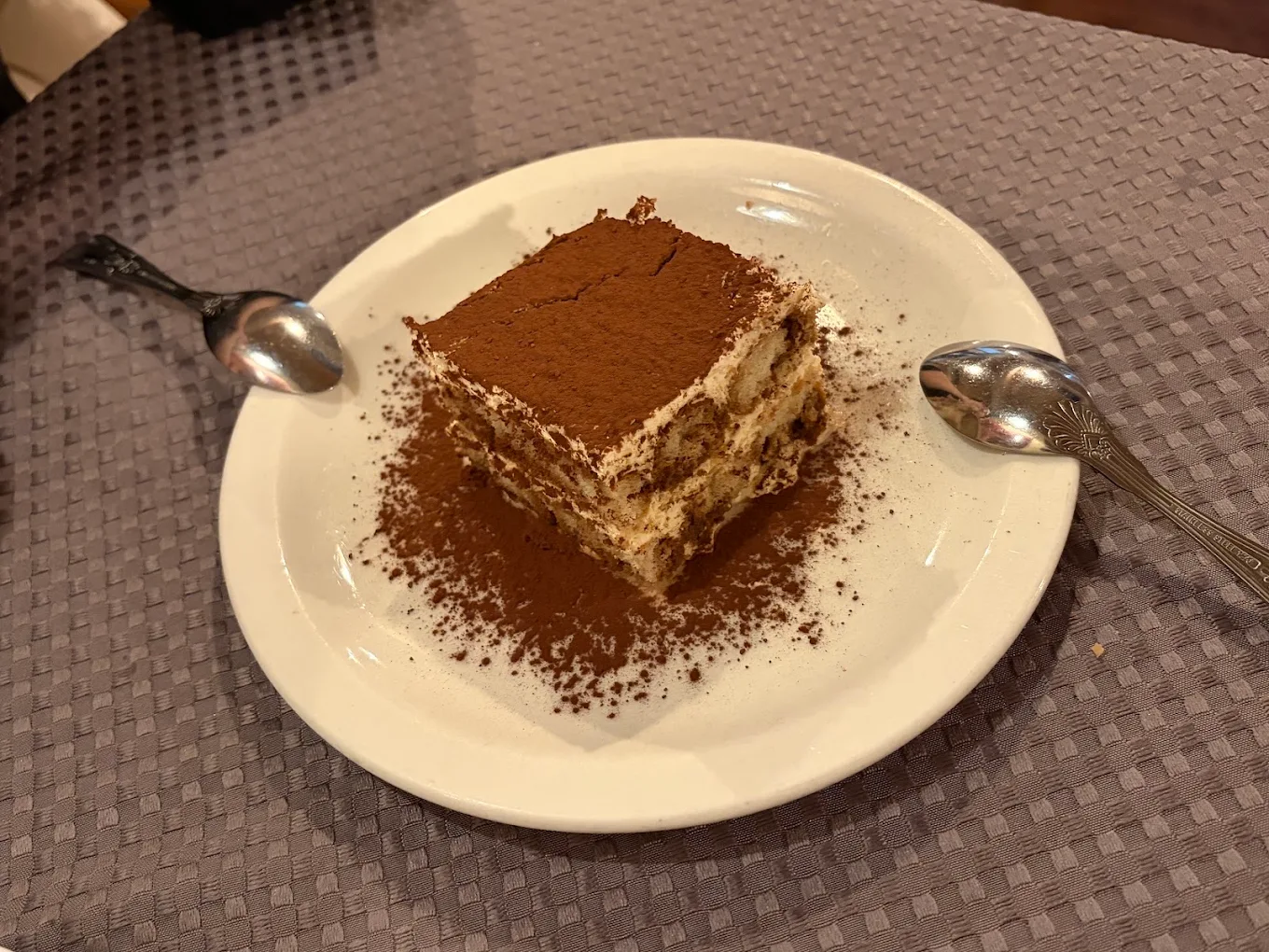 Fabio’s layered tiramisu dusted with cocoa, with two spoons ready to share